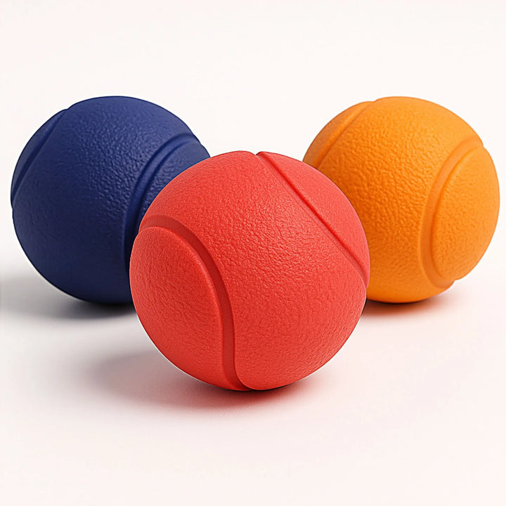 Ensemble de trois balles solides pour chien : bleue, rouge et orange.