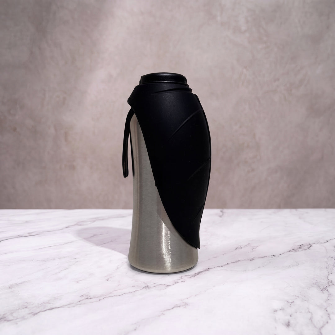 Gourde isotherme pour chien noir mat et inox de 750ml debout, écuelle feuille en silicone refermée.