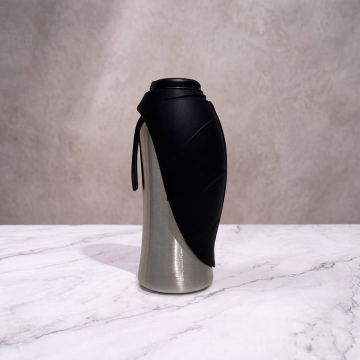 Gourde isotherme pour chien noir mat et inox de 750ml debout, écuelle feuille en silicone refermée.