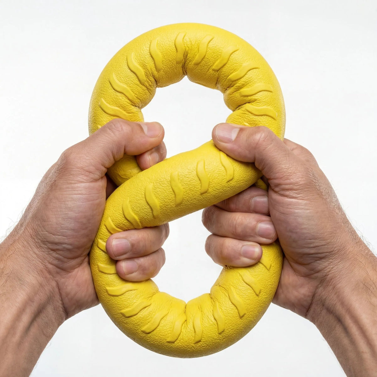 Mains montrant la flexibilité et la solidité de l'anneau de dentition pour chien en caoutchouc.